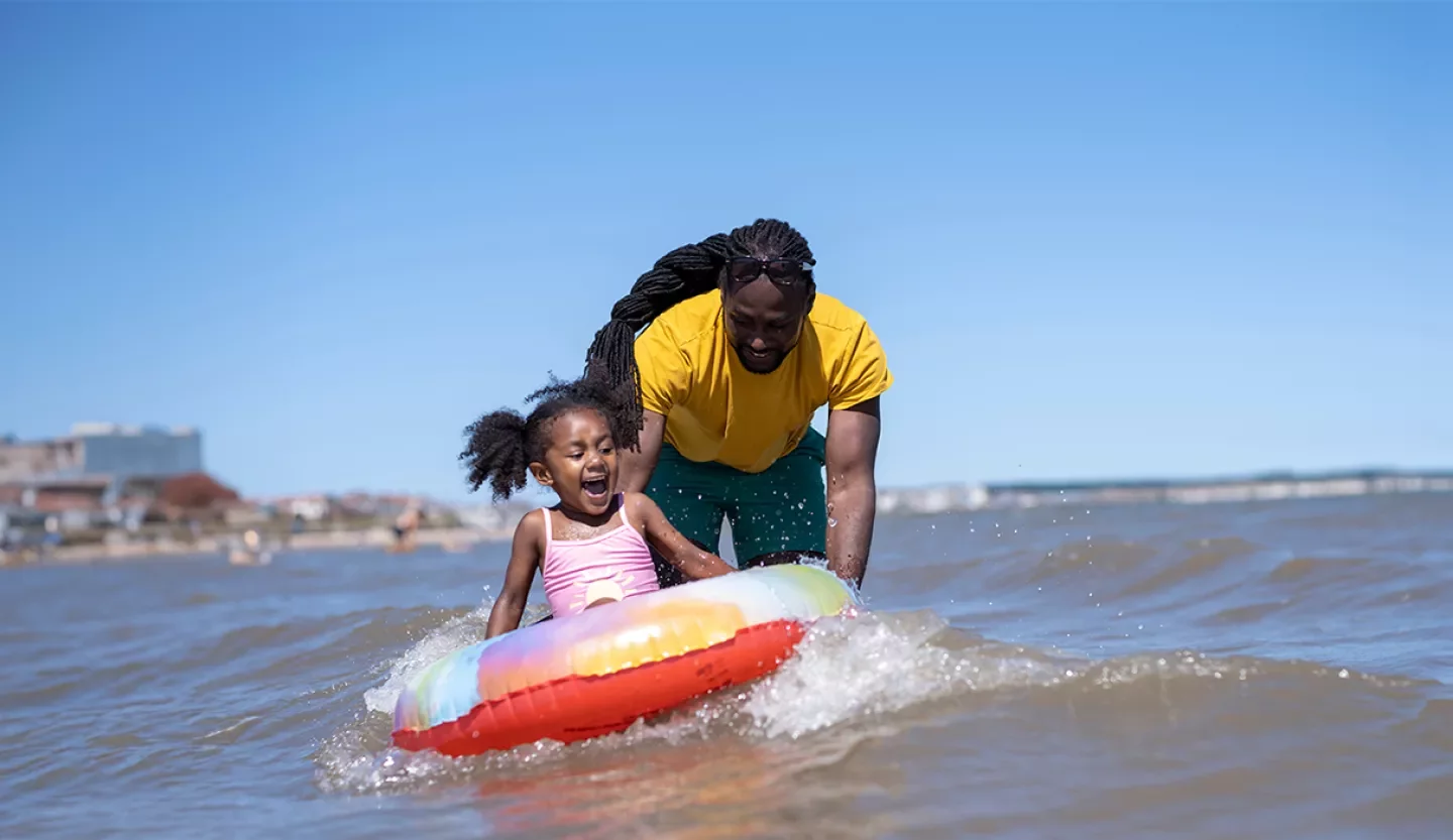 family playing in ocean